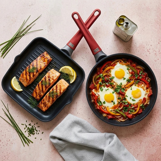 מארז מחבתות 28 ס"מ גריל + 24 TITANIUM FLAME ידית אדומה | Create a single, hyper-realistic overhead (top-down) food photography shot, in the natural editorial style of "Visual Reference 1" — same soft window-light qual