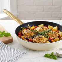 מחבת 32 ס"מ ENIGMA NONSTICK קרם ידיות שמפניה | Surround the cookware with light, airy styling props in the same clean, minimal, natural-light mood as "Visual Reference 1" — choose 1-2 simple elements such as